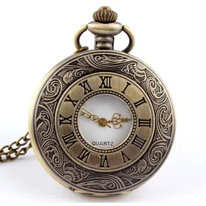 Primer plano de reloj de bolsillo de bronce con números romanos y tapa grabada.
