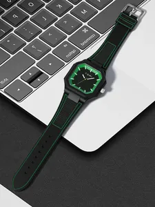 Détail de la montre en silicone carrée TOMI avec accents verts sur un ordinateur