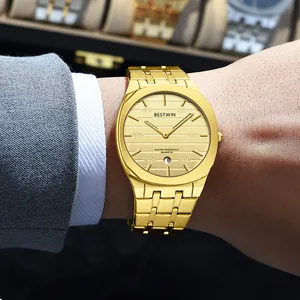 Macro detail of a gold men's fashion quartz watch with steel band and date display on a wrist