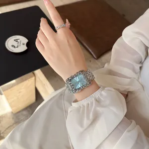 Primo piano dettagliato di un orologio quadrato vintage argento con quadrante azzurro al polso.