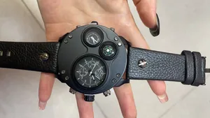 Nahaufnahme der Oulm Herrenuhr mit zwei Zeitzonen und integriertem Kompass in der Hand
