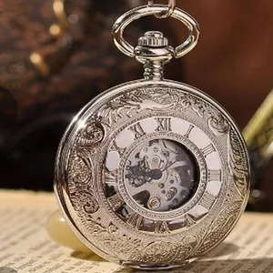 Gros plan d'une montre à gousset mécanique argentée vintage avec des gravures florales