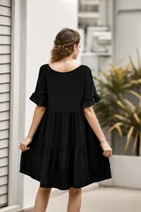 Elegante Rückansicht eines lässigen schwarzen gestuften Babydoll-Sommerkleids.