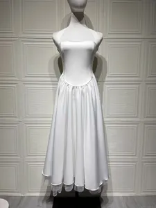 Vooraanzicht van een elegante witte halteravondjurk met een gepofte plooirok op een pop