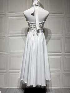 Achteraanzicht van een witte halteravondjurk met elegante vetersluiting op de rug