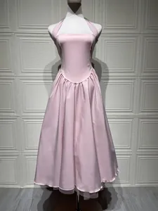 Gedetailleerd overzicht van een elegante roze halteravondjurk met wijde plooirok