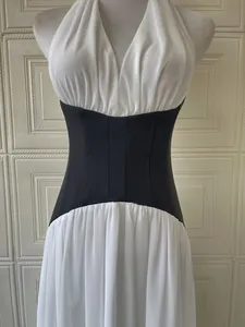Close-up detail of a French style white halter dress featuring a black corset waist design