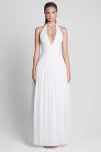 Elegant white halter-neck evening gown with deep V-neck and flowing skirt detail.