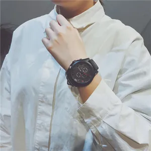Detailed view of a black large dial men's sports watch on a white shirt background.