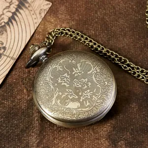 Vue détaillée d'une montre à gousset en bronze antique avec gravures florales sur le couvercle.