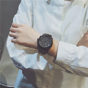 Close-up of a trendy large dial sports watch worn on a wrist with a white shirt.