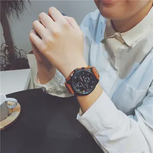 Close-up of a men's large black dial sports watch with a stylish brown strap