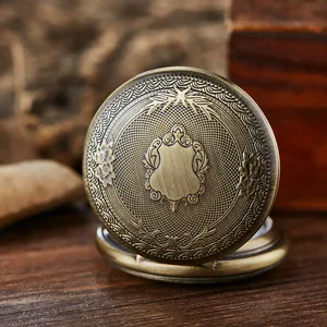 Gros plan d'une montre de poche en bronze vintage avec gravure florale sur le couvercle