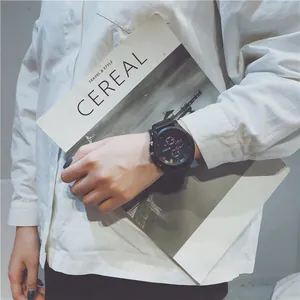 Close-up of a stylish men's sports watch with a large black dial worn on wrist.
