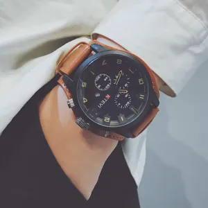 Close-up of a large black dial sports watch with a wide brown leather strap on a wrist.