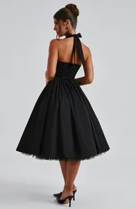 Gedetailleerd achteraanzicht van elegante zwarte halter puff jurk met een grote strik