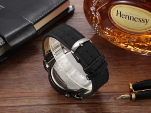 Vista macro de la correa de reloj negra texturizada con hebilla de plata para hombre