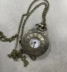 Vista detallada de un reloj de bolsillo vintage de bronce con números romanos y cadena