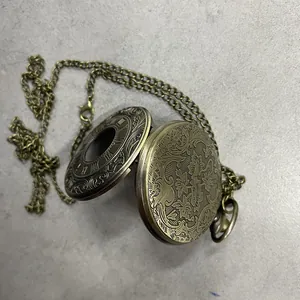 Reloj de bolsillo vintage en bronce con grabados florales y números romanos detallados