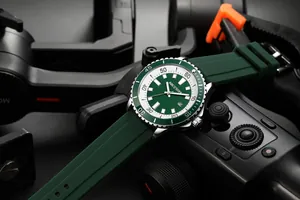 Close-up of AOCASDIY men's watch with green dial and silicone strap on camera gear