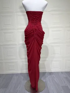 Back view of elegant red strapless dress with lace-up corset and ruched draping.