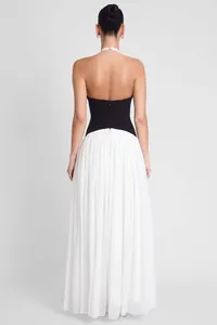 Back view of a French style backless halter maxi dress with black bodice and white skirt