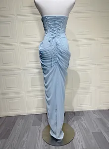 Back detail of light blue strapless evening gown with corset lace-up and elegant ruched texture.