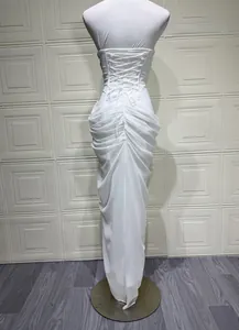 Back detail of a white strapless ruched evening gown featuring a lace-up corset closure