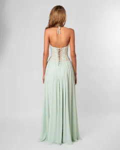 Gedetailleerd achteraanzicht van een mintgroene halter maxi-jurk met kanten korset en plooirok