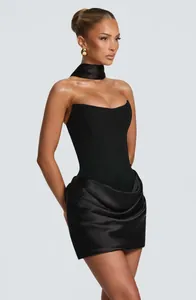 Detailed view of a chic black strapless corset mini dress with draped satin skirt detail.