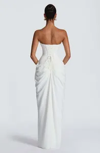 Back view of elegant white strapless dress with corset tie and draped skirt detail