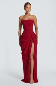 Elegant red strapless floor-length gown with pleated bodice and thigh-high split detail
