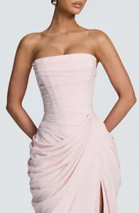 Detail view of an elegant strapless light pink dress featuring a pleated bodice and side slit