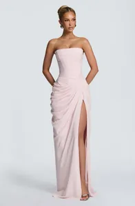 Full view of an elegant strapless pleated evening gown with high slit in soft pink.