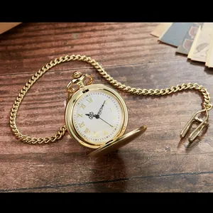Elegante goldene Taschenuhr im Vintage-Stil mit römischen Ziffern auf Holzschreibtisch.