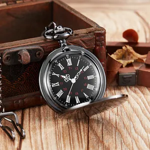 Vue rapprochée d'une montre à gousset noire vintage avec chiffres romains sur décor en bois.