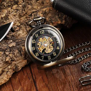Gros plan d'une montre de poche mécanique avec engrenages squelette et fini bronze.