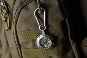 Detailansicht der taktischen Karabineruhr befestigt an einem olivgrünen Rucksack