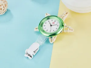 Detailed view of a green quartz nurse watch with a white clip and medical dial