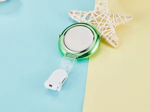 Close-up of stylish green quartz nurse fob watch with white clip on pastel background.