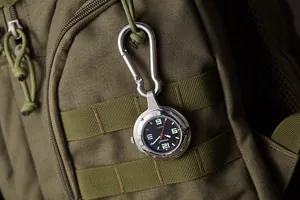 Taktische Karabineruhr mit Leuchtzifferblatt an einem armee-grünen Outdoor-Rucksack