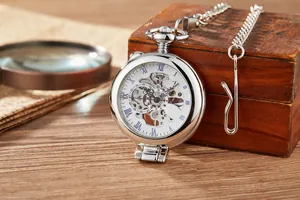 Gros plan d'une montre de poche mécanique argentée avec cadran squelette vintage