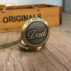 Vintage χάλκινο ρολόι τσέπης με χάραξη 'The Greatest Dad' σε ξύλινο τραπέζι