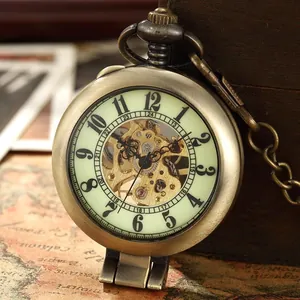 Montre à gousset mécanique dorée vintage avec cadran squelette sur une carte ancienne
