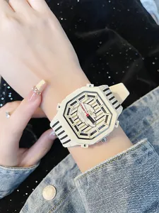 Primo piano di un orologio ottagonale beige alla moda con quadrante a piuma al polso
