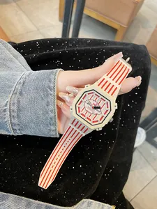 Dettaglio di un orologio da donna alla moda con strisce rosse e bianche e quadrante ottagonale