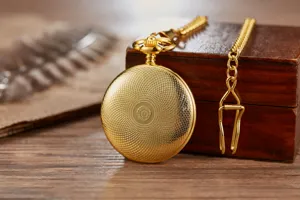 Detailed view of a vintage gold mechanical pocket watch featuring an ornate textured cover.