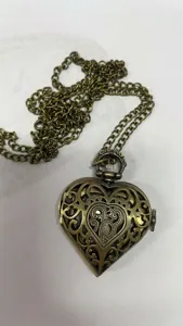 Gedetailleerd overzicht van vintage bronzen hartvormige filigraan zakhorloge ketting