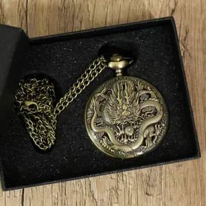 Detailaufnahme einer antiken Bronze-Quarz-Taschenuhr mit geschnitztem Drachenmuster.