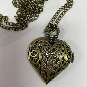 Vintage hartvormig zakhorloge in brons met hol bloemmotief en lange ketting